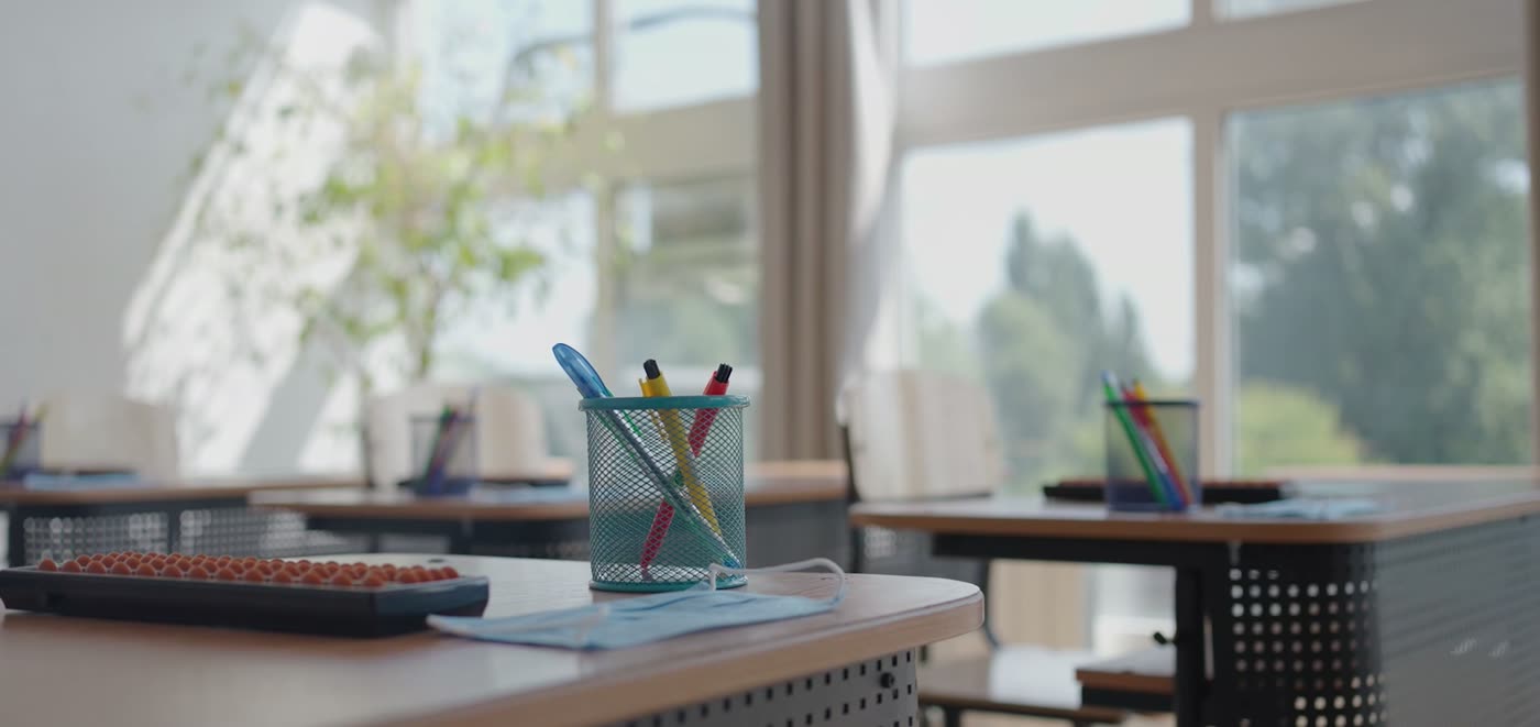 Pencils and pens in a jar on a classroom desk